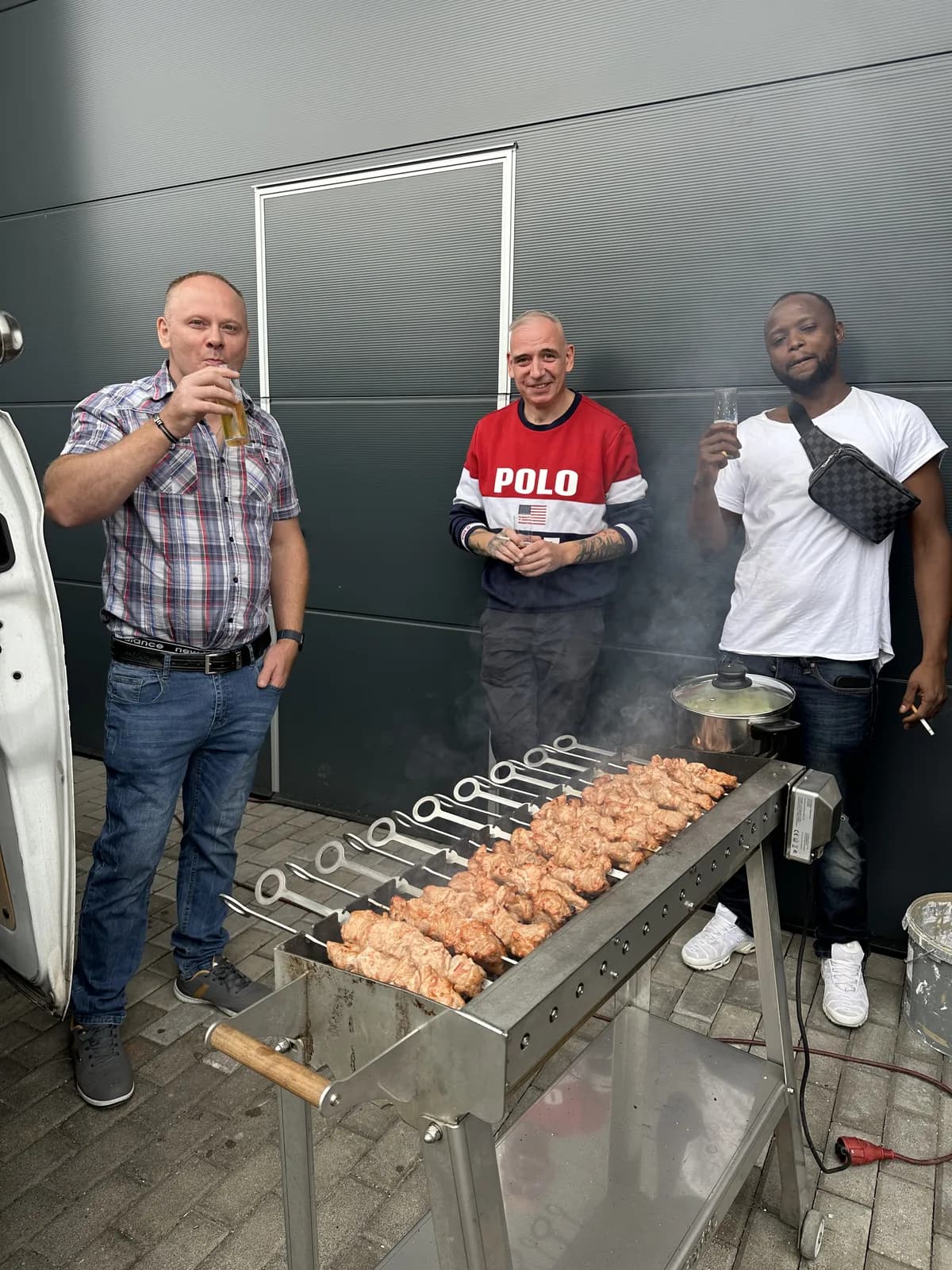 Drei Kollegen am Spießgrill vor der Halle beim Sommerfest 2026 von SKZ Rheinland
