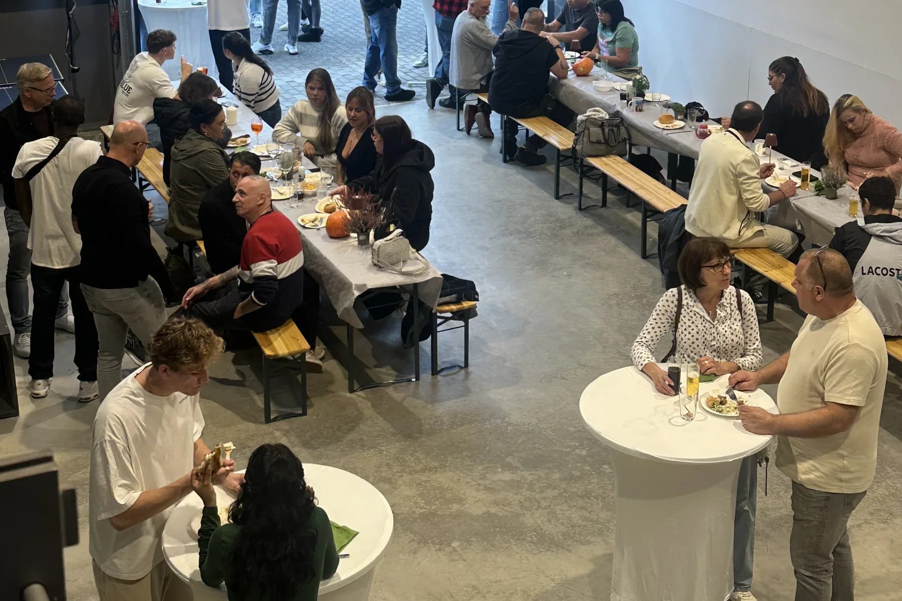 Das Team von SKZ Rheinland an langen Biertischen in der Halle beim Sommerfest 2026